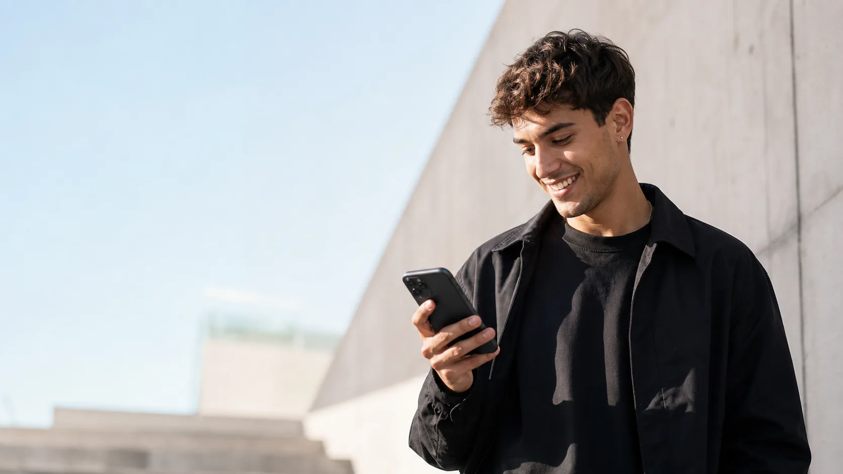 A creator smiling at his phone after monetizing content